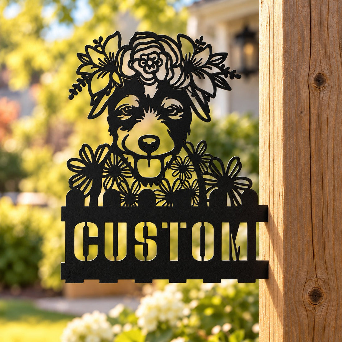 Black custom metal dog house number sign with floral crown mounted on a wooden post outdoors