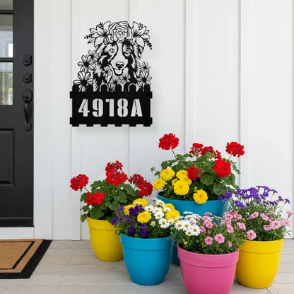 Australian Shepherd custom metal house number sign in black, flush mounted on white porch siding beside a black front door with colorful potted flowers