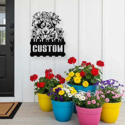 Corgi custom metal house number sign in black, flush mounted on white porch siding beside a black front door with colorful potted flowers