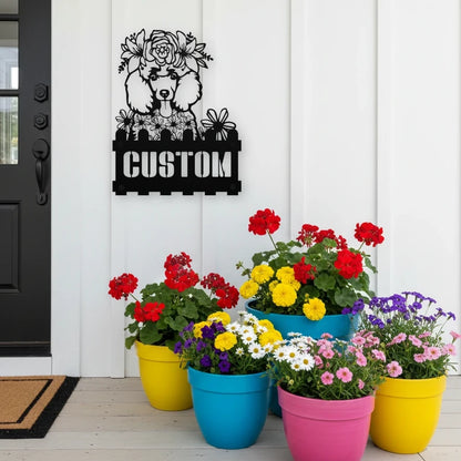 Poodle custom metal house number sign in black, flush mounted on white porch siding beside a black front door with colorful potted flowers