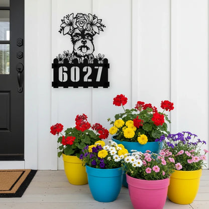 Schnauzer custom metal house number sign in black, flush mounted on white porch siding beside a black front door with colorful potted flowers
