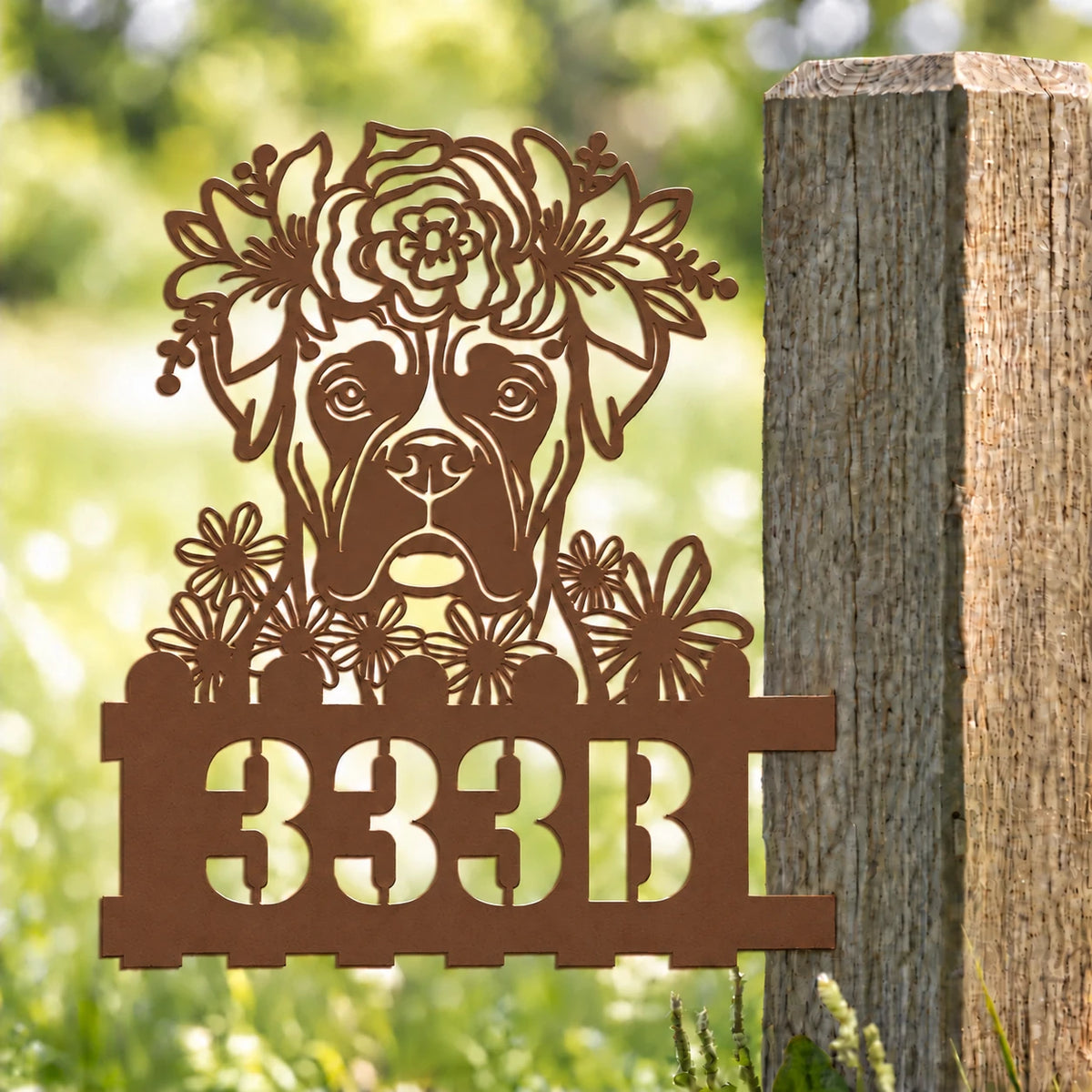 Boxer custom metal house number sign with floral crown mounted on a garden post.